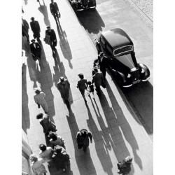 CROWD OF PEOPLE STROLLING DOWN CITY SIDEWALK