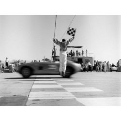 Man jumping waving checkered flag